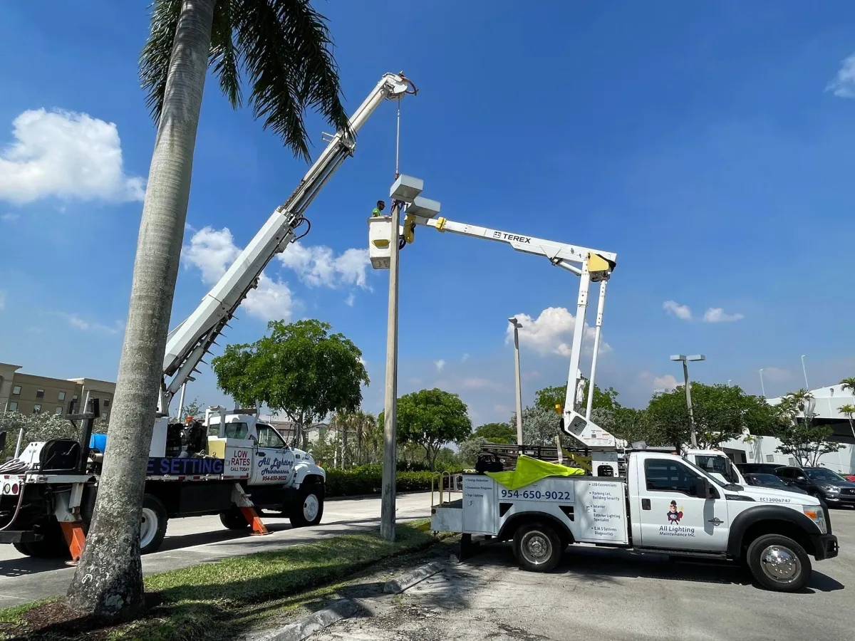 All Lighting Maintenance crane truck and Terex bucket truck collaborating to install a new concrete light pole and LED fixture.