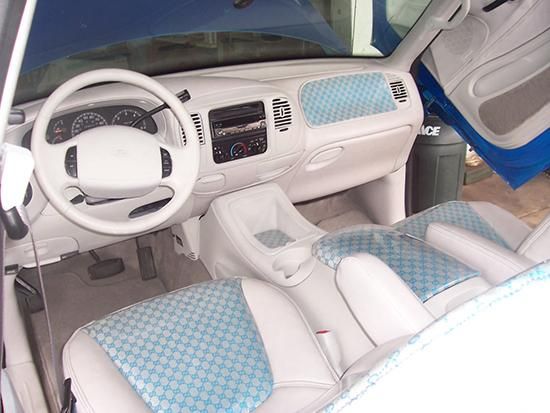 Customized white leather and light blue patterned fabric truck interior featuring a matching dashboard and seats by AE Auto Upholstery in Melbourne, FL.
