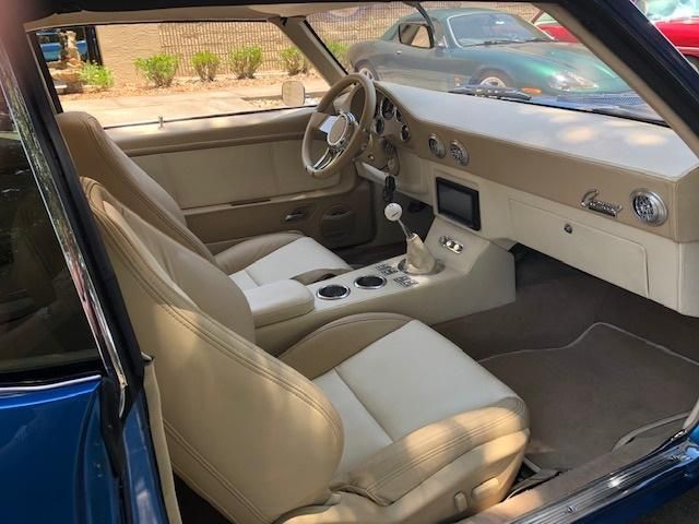 Customized tan and cream leather interior for a classic Chevrolet Camaro restomod, featuring a leather-wrapped dash and custom console by AE Auto Upholstery in Melbourne, Florida.