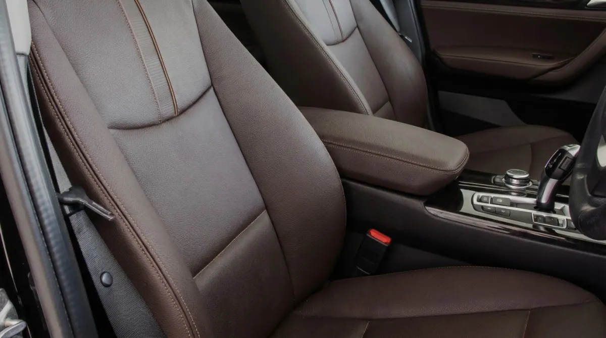 Custom deep brown leather seat upholstery and matching armrest for a modern luxury vehicle by AE Auto Upholstery in Melbourne, Florida.