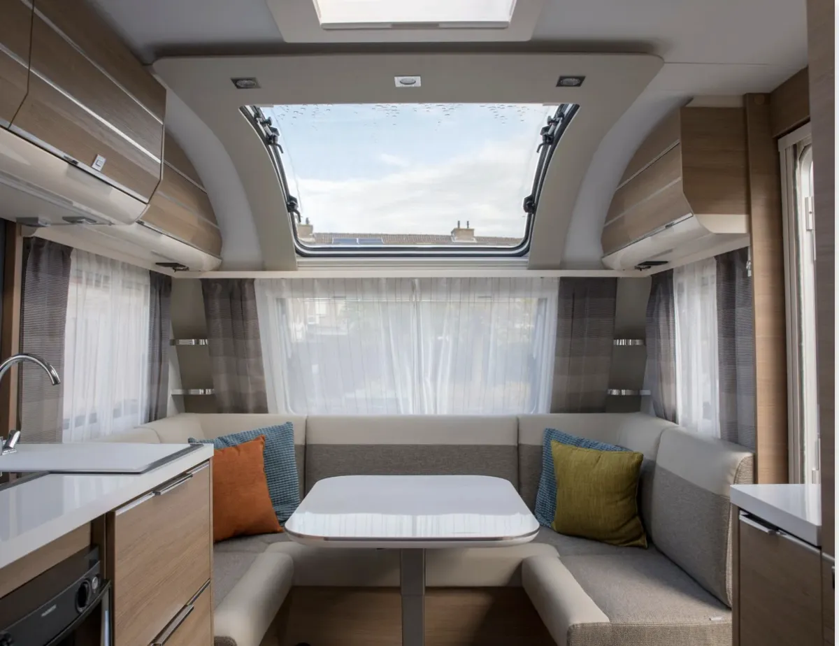 Clean modern RV dinette area with custom upholstered beige and grey cushions by AE Auto Upholstery in Melbourne, Florida.