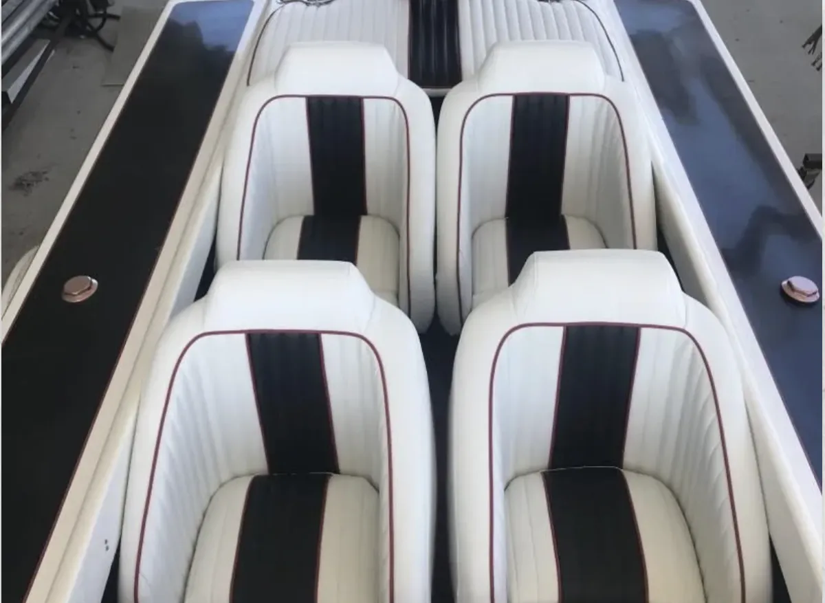 Overhead view of four custom white and black marine vinyl boat seats with red piping, professional marine upholstery in Melbourne, FL.