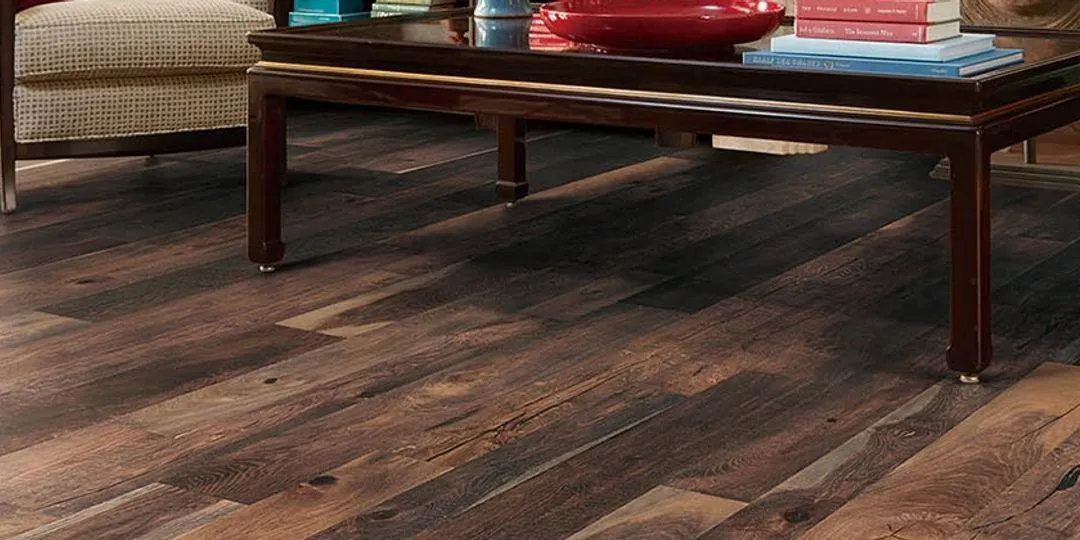 Rich dark hardwood flooring with natural grain installed in a living room.